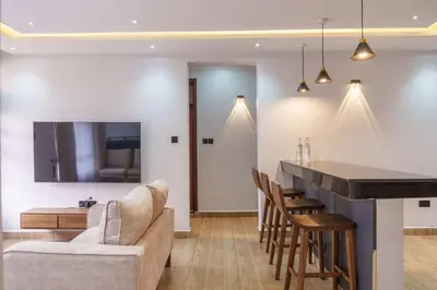 a kitchen and living room with a bar and a couch at Sereni Homes in Arusha