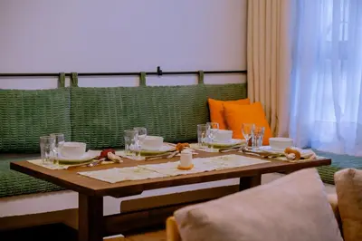 a wooden table with plates and glasses on it at Sereni Homes in Arusha