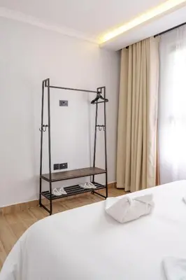 a bedroom with a white bed and a mirror at Sereni Homes in Arusha
