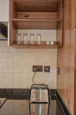 a kitchen with a toaster and glasses on a shelf at Sereni Homes in Arusha