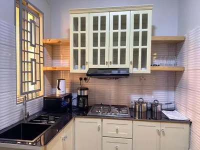 a kitchen with white cabinets and a stove top oven at Kilimanjaro Peponi Villas in Msaranga