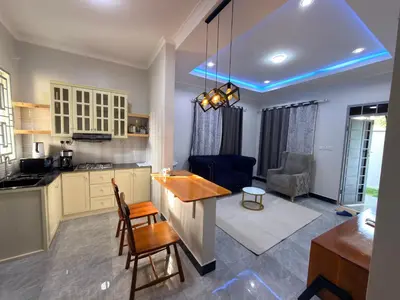 a kitchen and living room with a table and chairs at Kilimanjaro Peponi Villas in Msaranga