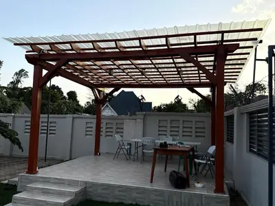 a wooden pergola with a table on a patio at Kilimanjaro Peponi Villas in Msaranga
