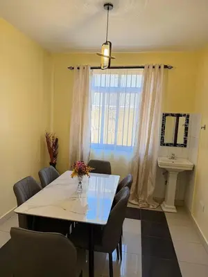 a dining room with a table and chairs and a window at Singi Homes in Nkunjila