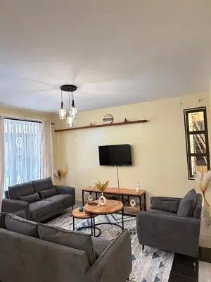a living room with couches and a flat screen tv at Singi Homes in Nkunjila