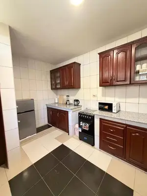 a kitchen with wooden cabinets and a black stove at Singi Homes in Nkunjila