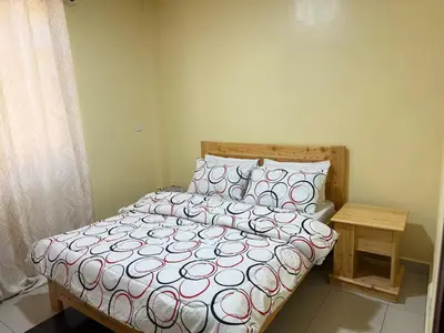a bedroom with a bed with a red and white comforter at Singi Homes in Nkunjila