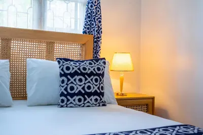 a bedroom with a bed with blue and white pillows at Noric Homes and Adventure in Msaranga