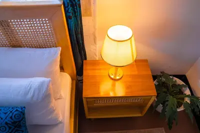 a lamp on a night stand next to a bed at Noric Homes and Adventure in Msaranga