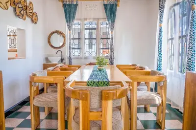 a dining room with a wooden table and chairs at Noric Homes and Adventure in Msaranga