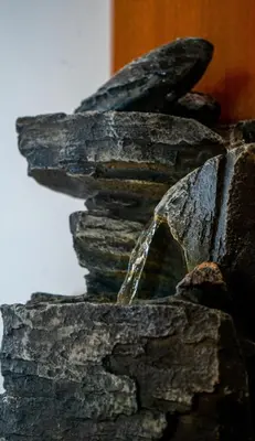 a stone wall with a stream of water pouring into it at AG Comfort Safari Homes in Arusha