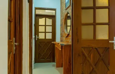 a bathroom with a wooden door and a mirror at AG Comfort Safari Homes in Arusha