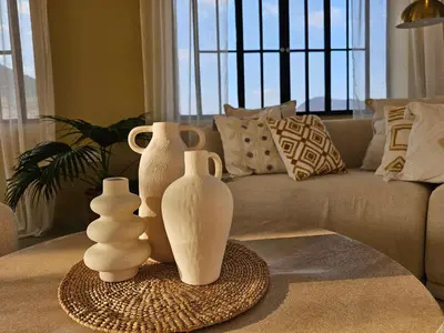 three white vases sitting on a table in front of a couch at Villa Miamba in Zame