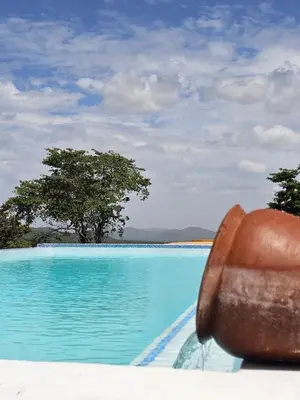 a large pool with blue water and a metal object at Villa Miamba in Zame