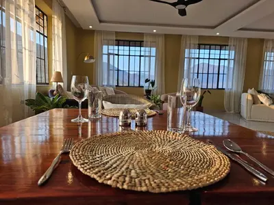 a wooden table with plates and wine glasses on it at Villa Miamba in Zame