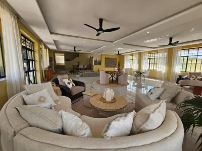 a large living room with couches and a ceiling fan at Villa Miamba in Zame