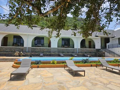 a group of chairs sitting next to a swimming pool at Villa Miamba in Zame