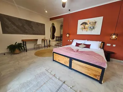 a bedroom with a bed with a red wall at Villa Miamba in Zame