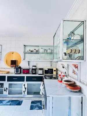 a kitchen with white cabinets and a counter top at KL shadow Homes in Arusha