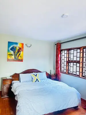 a bedroom with a large white bed in it at KL shadow Homes in Arusha