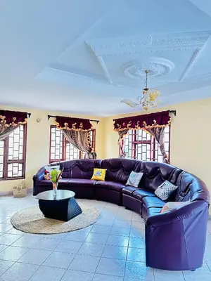 a living room with a purple couch and a table at KL shadow Homes in Arusha