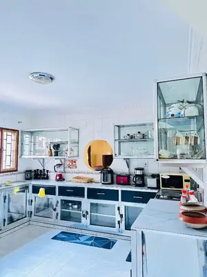 a kitchen with white cabinets and blue counters at KL shadow Homes in Arusha