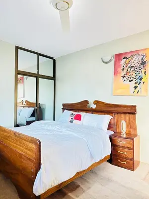 a bedroom with a large wooden bed and a window at KL shadow Homes in Arusha