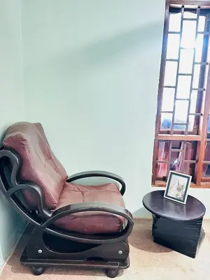 a chair sitting in a room next to a window at KL shadow Homes in Arusha