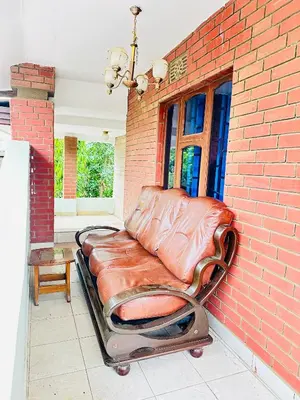 a leather couch sitting next to a brick wall at KL shadow Homes in Arusha