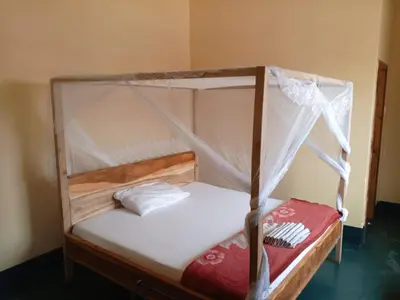 a bunk bed with white sheets and a canopy at New Siesta Inn in Nkunjila
