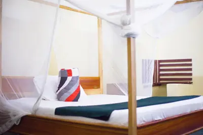 a bed with a canopy with a pillow on it at New Siesta Inn in Nkunjila