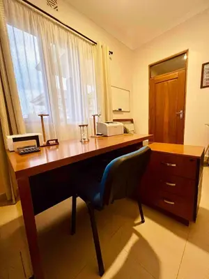 a wooden desk with a chair in a room at Small White House Njiro in Arusha