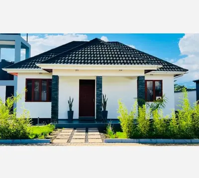 a white house with a black roof at Small White House Njiro in Arusha
