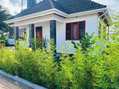 a small white house with a black roof at Small White House Njiro in Arusha