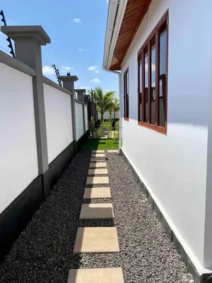 a walkway next to a white building at Small White House Njiro in Arusha