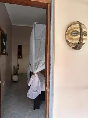 a door to a room with a mask on the wall at Meru Nest Arusha Bed & Breakfast in Arusha