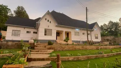 a white house with a black roof at Meru Nest Arusha Bed & Breakfast in Arusha