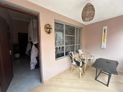 a room with a table and a chair and a window at Meru Nest Arusha Bed & Breakfast in Arusha