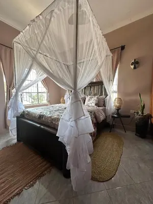 a bedroom with a bed with a canopy at Meru Nest Arusha Bed & Breakfast in Arusha