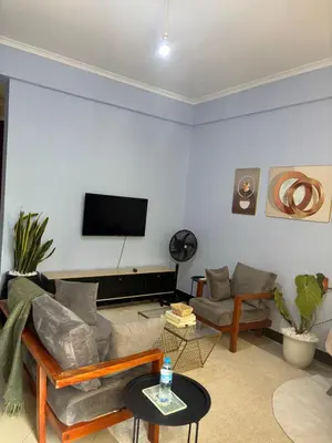 a living room with a couch and a flat screen tv at Wimake homes in Arusha