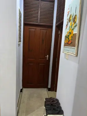 a hallway with a wooden door and a pile of shoes at Wimake homes in Arusha