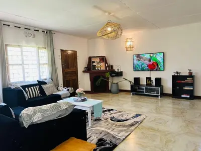 a living room with a couch and a tv at The Manor Garden House - Arusha Eight-Minute City Stay in Arusha