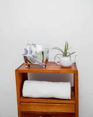 a wooden shelf with a mirror and a plant on it at The Manor Garden House - Arusha Eight-Minute City Stay in Arusha