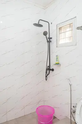 a shower with a pink bucket in a bathroom at The Manor Garden House - Arusha Eight-Minute City Stay in Arusha