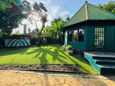 a yard with a green house with a green lawn at Oldadai Falls Retreat in Arusha