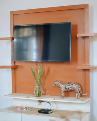 a shelf with a television and a toy leopard on it at Arusha 2bedroom in Arusha