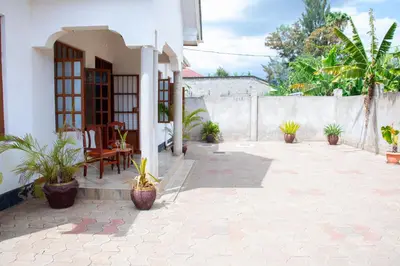 a patio with potted plants and a building at Arusha 2bedroom in Arusha