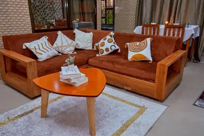 a living room with a brown couch and a table at Zaal stays in Arusha