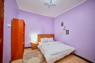 a bedroom with a bed and a purple wall at Zaal stays in Arusha