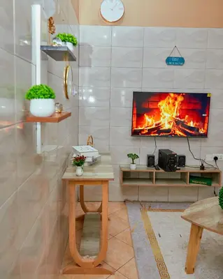 a living room with a fireplace in the wall at Zaal stays in Arusha